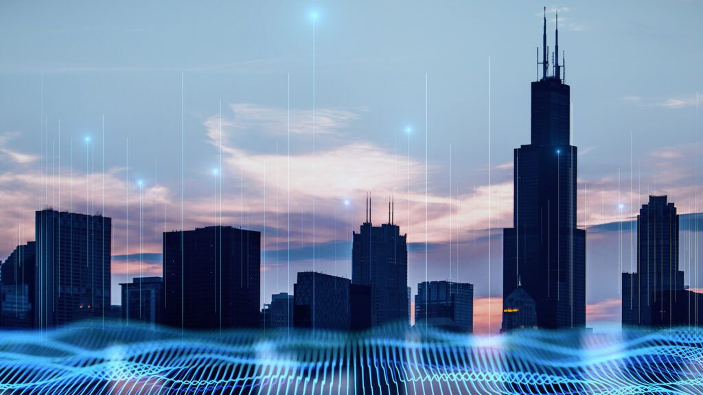 Blue digital wavy wires and antennas on night city skyscraper. Adobe Stock
