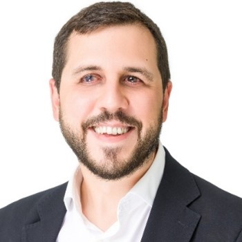 Alejandro Moledo del Río, white male with dark hair and beard, smiling, wearing a black suit and white shirt.